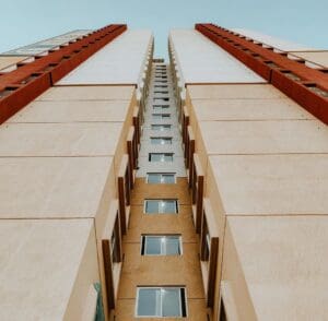 Edifício alto visto de baixo para cima, simbolizando fluxo contínuo, produtividade e eficiência na construção civil, conceito central do sistema lean para redução de prazos e aumento de resultados em obras.