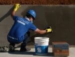 Técnico aplicando sistema de impermeabilização em piscina durante obra, garantindo proteção contra infiltrações.