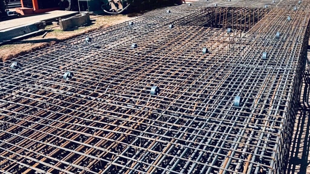 Estrutura de armação de aço para fundação, detalhando a montagem técnica e a precisão na construção civil.