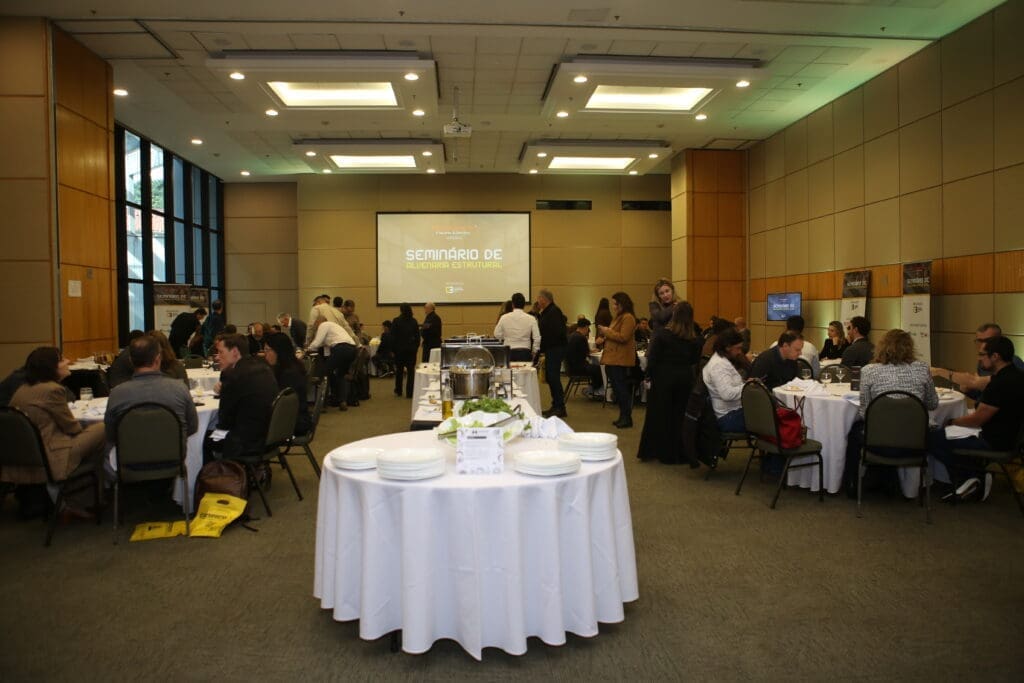 Convidados do Seminário de Alvenaria Estrutural do C3 participam de almoço exclusivo em salão reservado, com mesas redondas e ambiente preparado para networking.