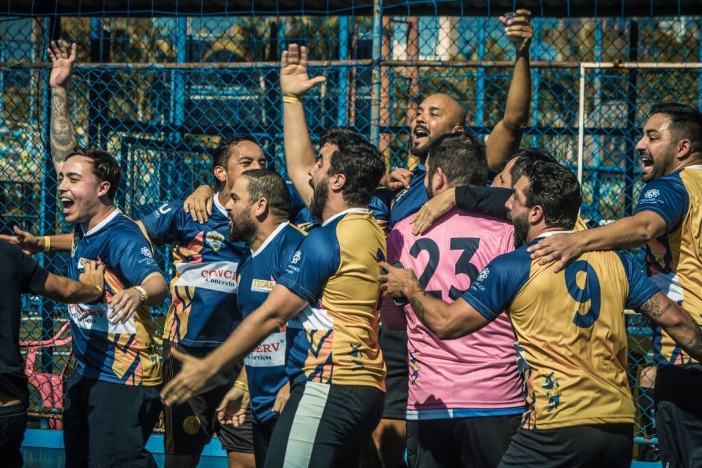 Jogadores da equipe Tegra comemoram juntos, abraçados e vibrando após conquista no Torneio Integração da Copa C3 2026, transmitindo união e alegria em campo.