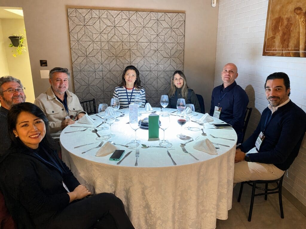Grupo de profissionais da construção civil reunidos ao redor de uma mesa redonda durante o 65° Almoço de Negócios do C3, em ambiente elegante e descontraído.