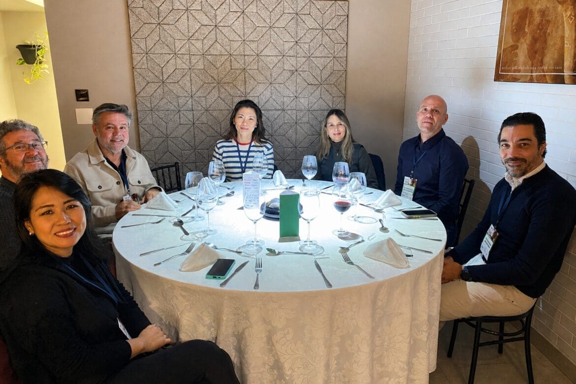 Grupo de profissionais da construção civil reunidos ao redor de uma mesa redonda durante o 65° Almoço de Negócios do C3, em ambiente elegante e descontraído.