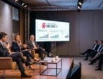 Painel de especialistas discute tendências do mercado imobiliário durante a Convenção Secovi-SP 2026, com público atento e gráficos de crescimento projetados no telão.