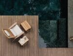 Poltrona deck da linha Marco da Tidelli, inspirada na cadeira Adirondack, com puff e mesa lateral em madeira, posicionados sobre deck ao lado de piscina.